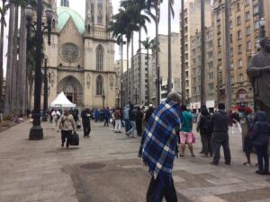 Moradores de rua em fila para retirar alimentos na Praça da Sé