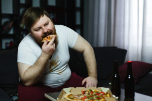 Obesidade x homem come pizza